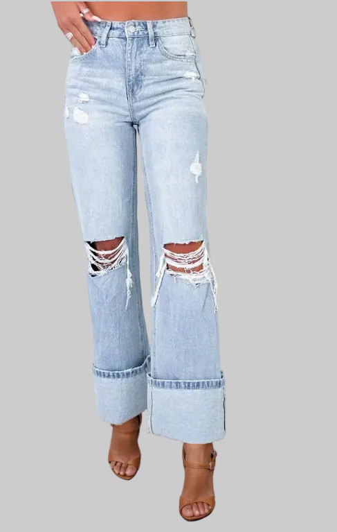 Light blue distressed jeans worn by a person standing on a wooden deck.