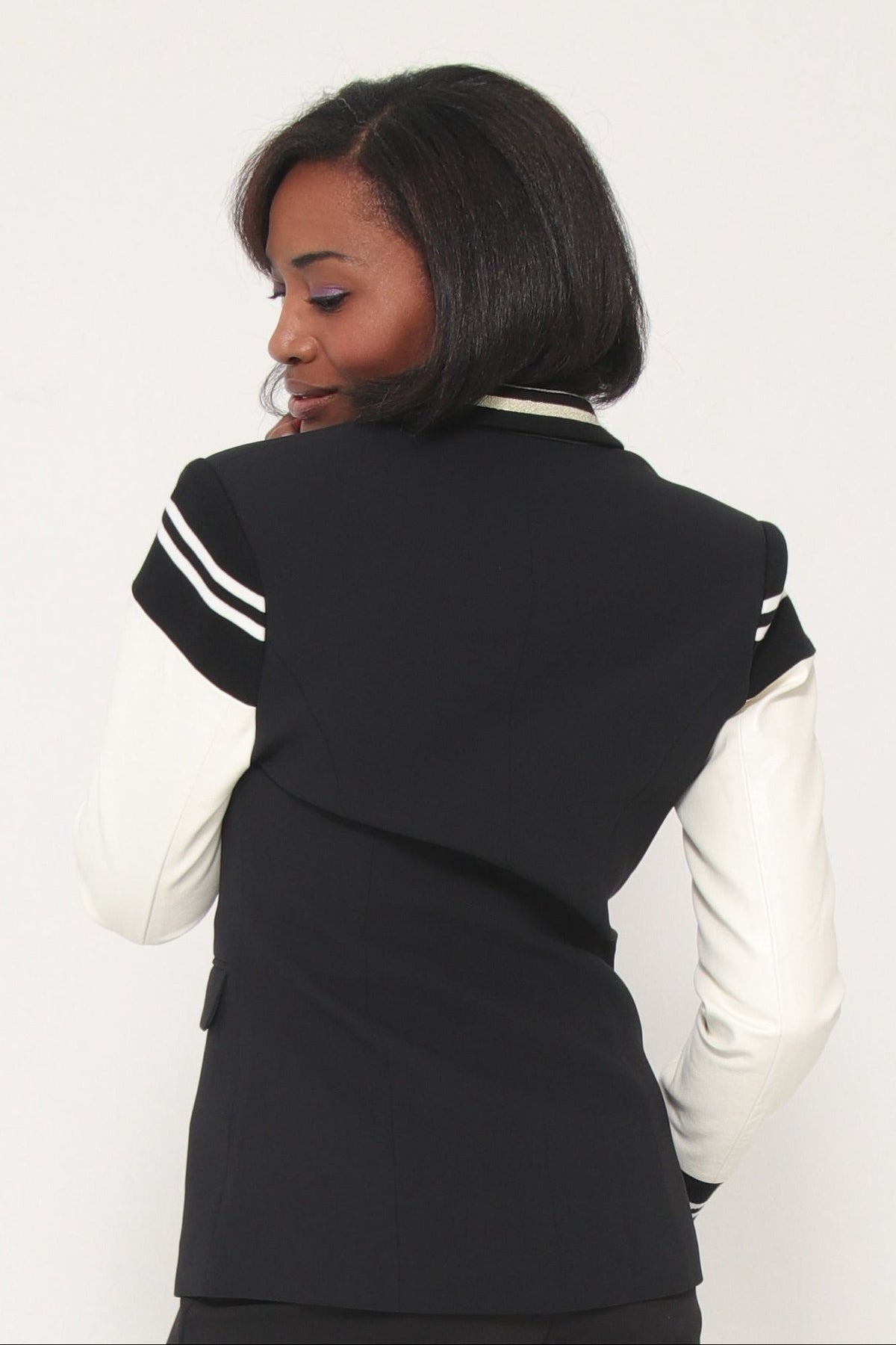 Person wearing a black outfit with white accents on a white background