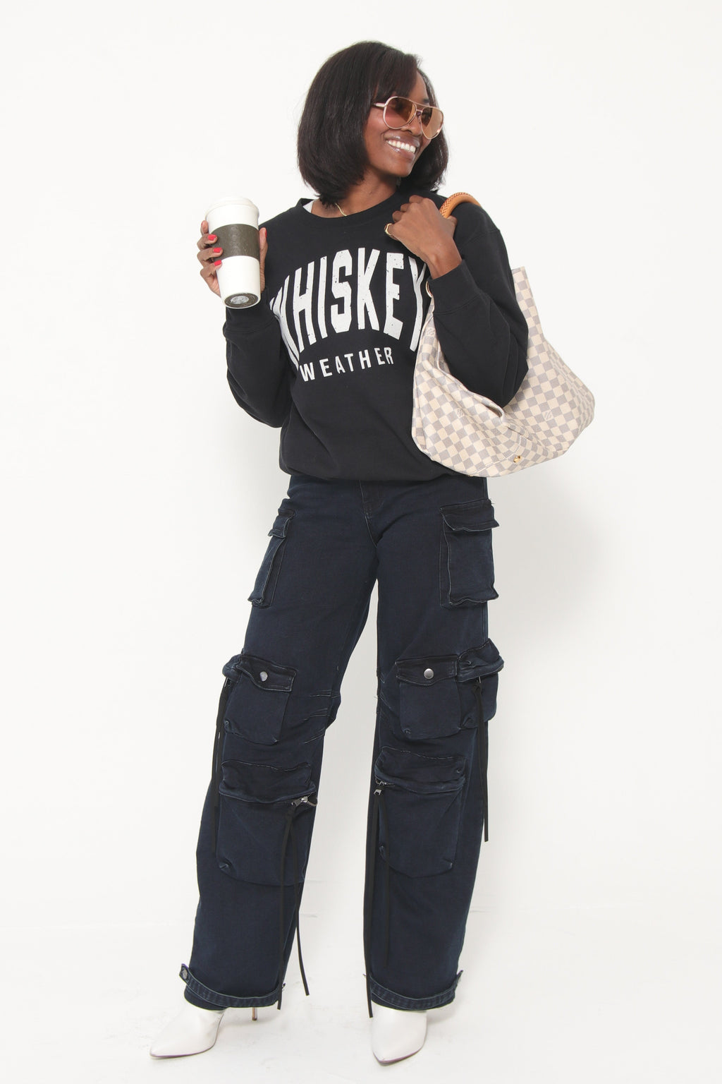 Person lying on a white surface wearing dark pants and a black shirt with text.