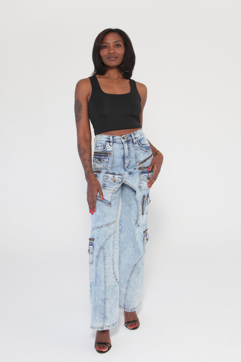 Person wearing a black top and light blue jeans on a white background