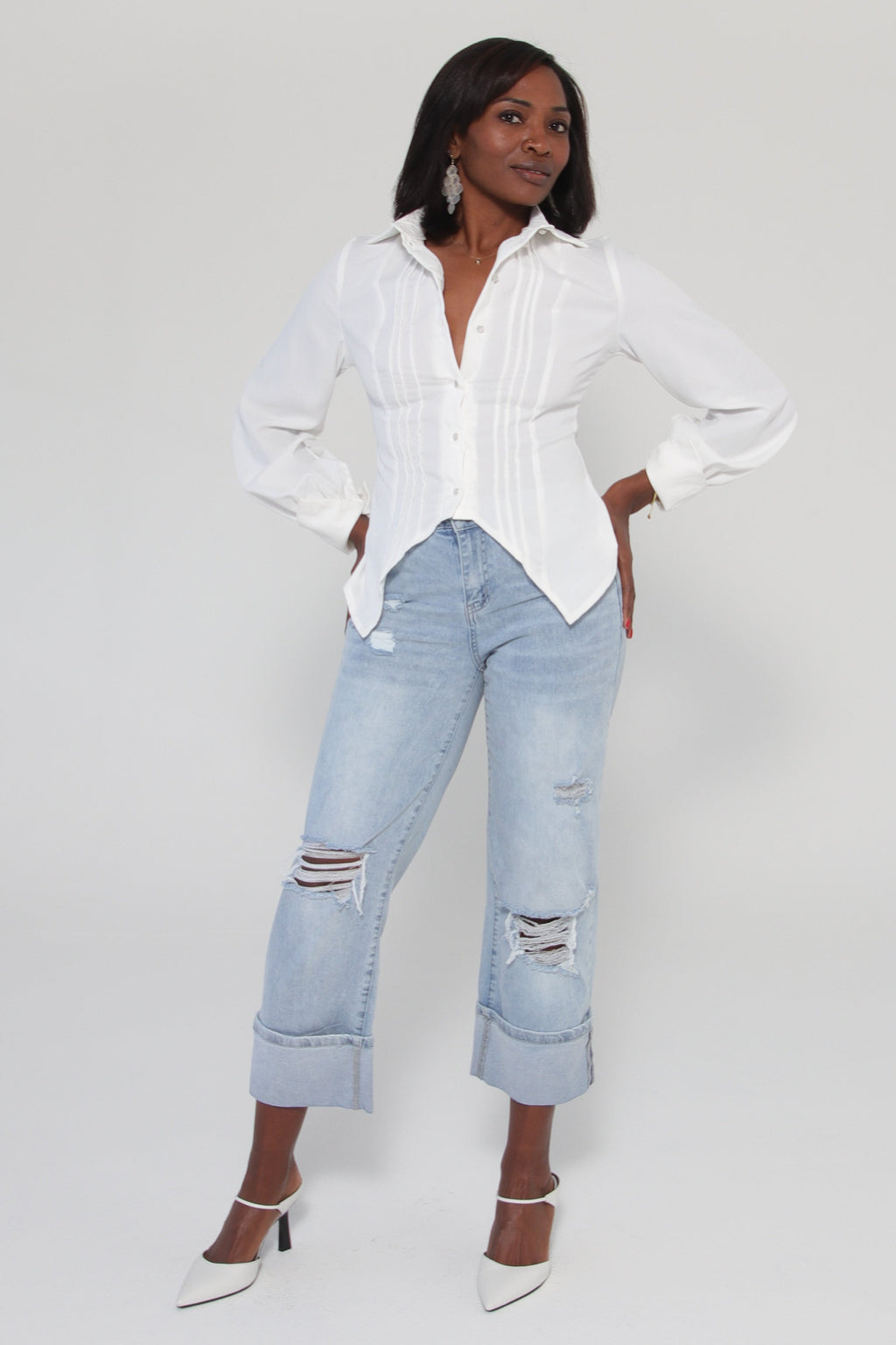 Person wearing a white top and light blue jeans on a white background