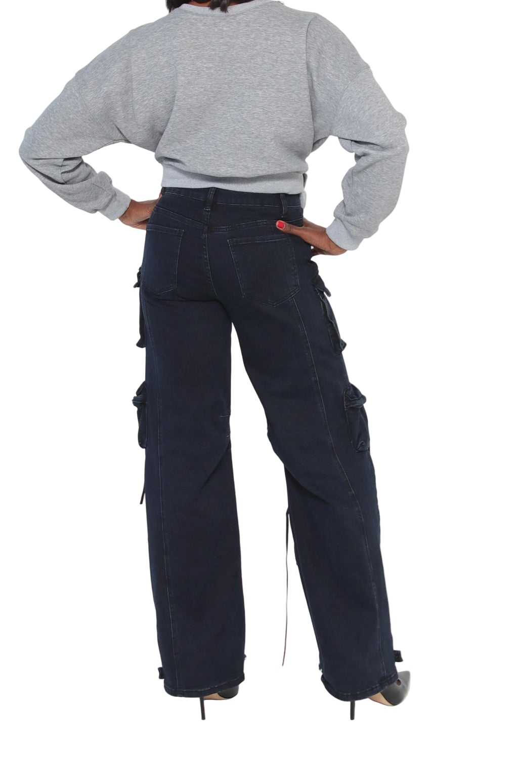 Person wearing dark blue cargo pants and a gray sweater on a white background