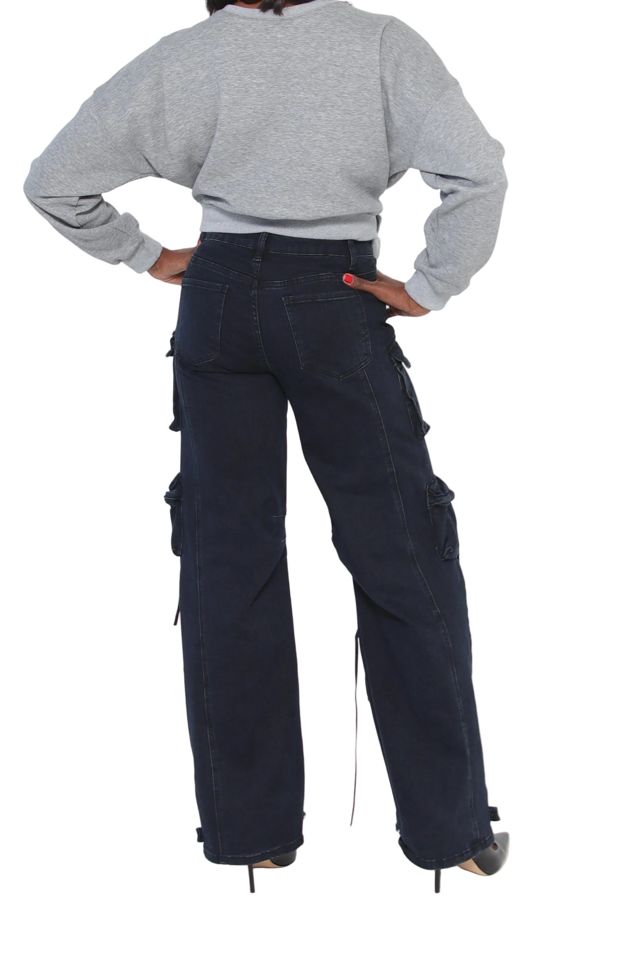 Person wearing dark blue cargo pants and a gray sweater on a white background