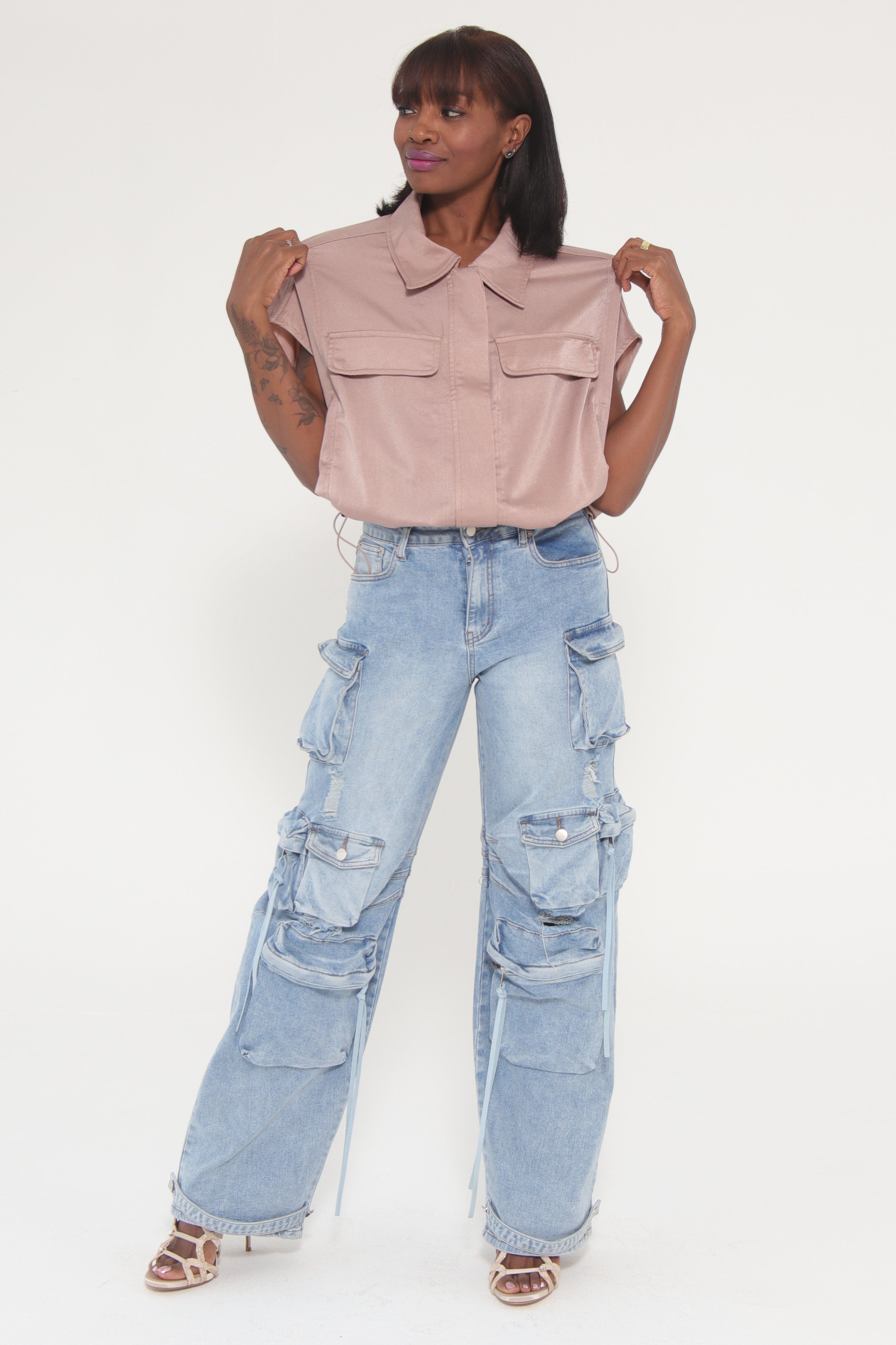 Person wearing light blue jeans and a pink shirt on a white background