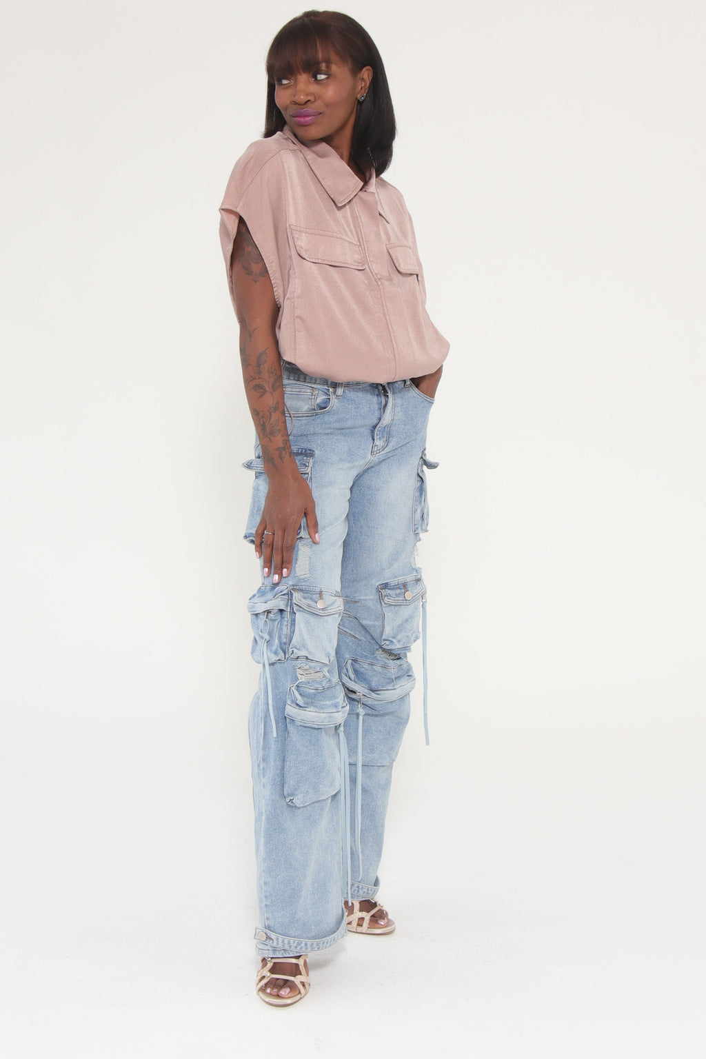 Person wearing a pink top and blue jeans on a white background