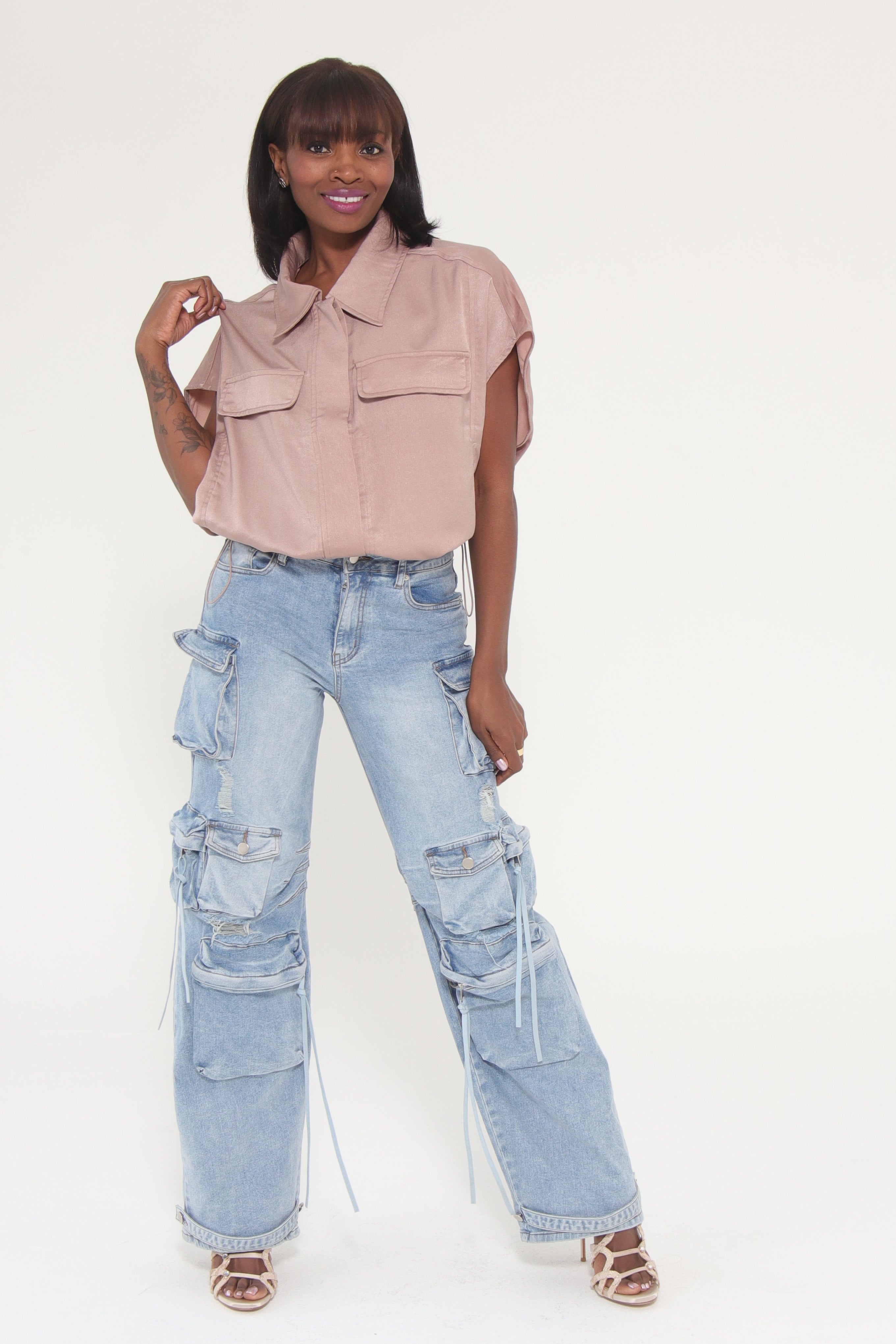 Person wearing light blue jeans and a pink sweater on a white background